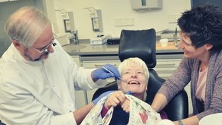 Zahnarzt mit Patientin und Mutter