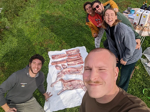 Julian Seitlinger und Kommilitonen bereiten zusammen ein Lamm zu. Auf einem Tuch auf dem Boden liegen die einzelnen Fleischstücke bereit.