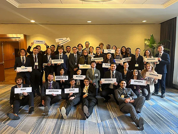 Gruppenfoto von Personen, die Schilder mit Ländernamen in den Händen halten.