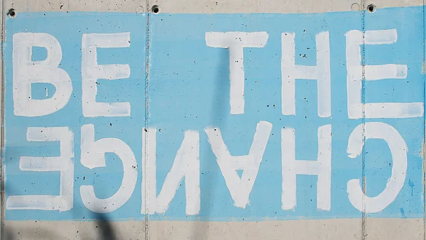 Schriftzug auf einer Mauer: be the change