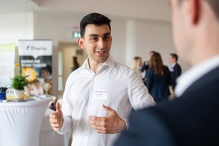Alumnus Amir Rahimi (Foto: UW/H) Amir Rahimi unterhält sich mit einem anderen Mann.