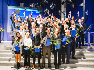 Die Absolvent:innen Lena Jakobi und Moritz Krauss gehören zum ersten Jahrgang des Bachelor-Studiengangs Wirtschaft, Politik und Recht. (Foto: Grubenglück) Gruppenfoto von Absolvent:innen, die ihre Hüte in die Luft werfen.