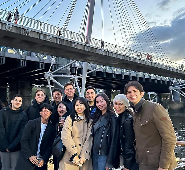 Studierende stehen vor einer Brücke in London.