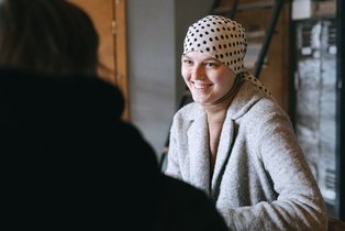 Frau mit Kopftuch im Gespräch in der Onkologie
