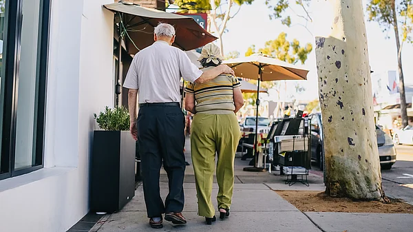 Älteres Paar spaziert auf dem Bürgersteig