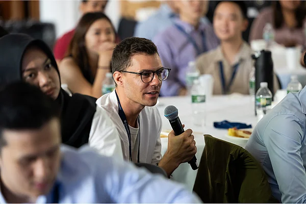 Ein Student spricht in ein Mikrofon.