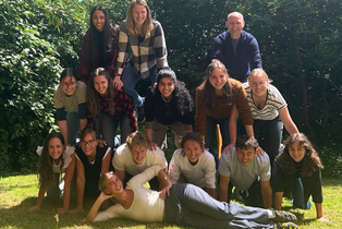 Gruppenbild der ersten LIC-Kohorte. Sie bauen eine Menschen-Pyramide auf dem Rasen.
