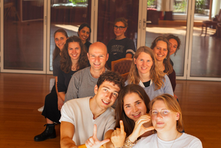Gruppenbild der ersten LIC-Kohorte. Sie sitzen hintereinander auf Stühlen.
