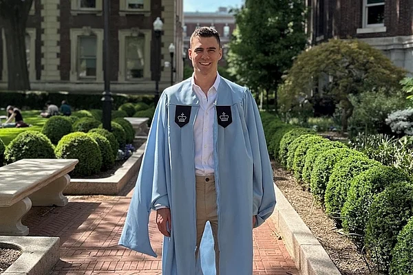 Ein Student steht auf einem Unicampus.